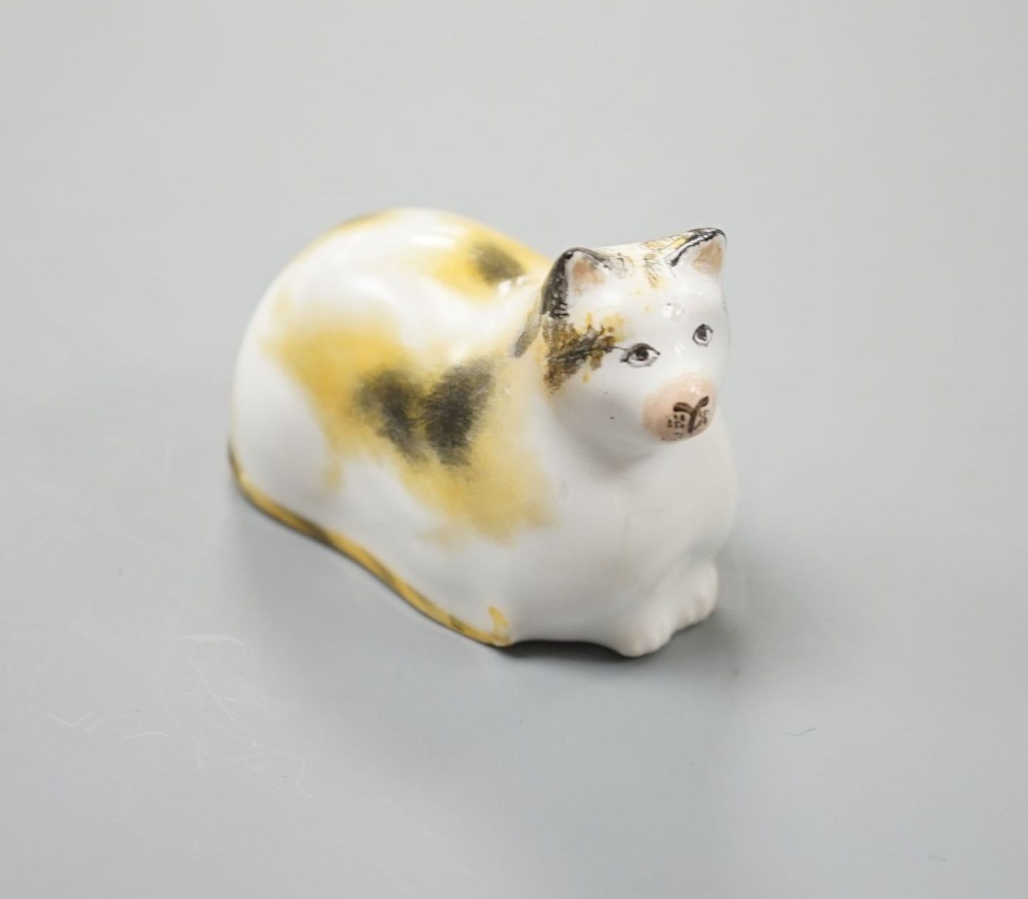 A rare Staffordshire porcelain figure of a recumbent cat, c.1835-50, with impossibly long tail, 6 cm long, Cf. Dennis G.Rice Cats in English porcelain, colour plate 54., Provenance: Dennis G.Rice collection